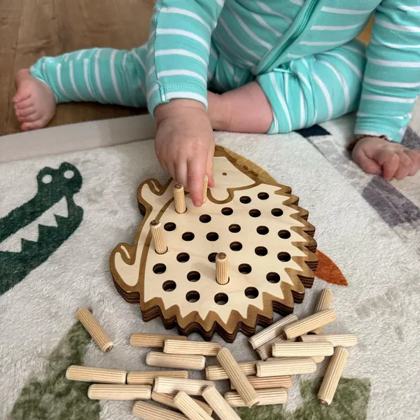 Kind spielt mit Holzigel – nachhaltiges Holzspielzeug zur Förderung der Feinmotorik